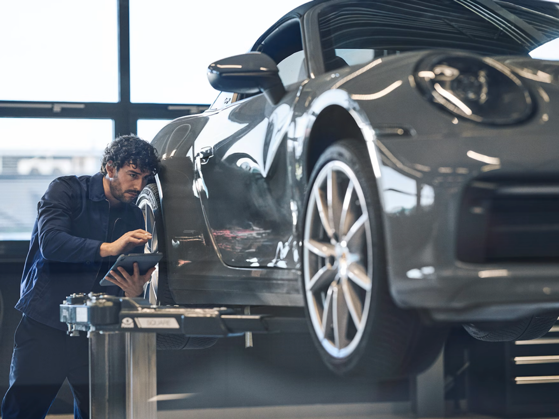 Porsche technician inspecting gray car