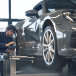 Porsche technician inspecting gray car